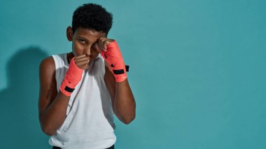 Kendine güvenen boksör çocuk ve kameraya bakıyor.