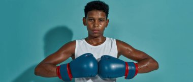 Kendine güvenen siyah çocuk boksör pozu ve kameraya bak.