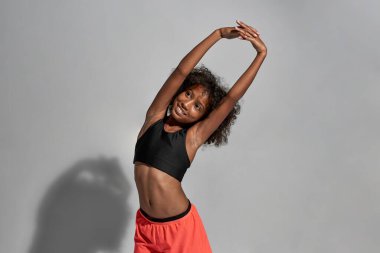 Gülümseyen atletik siyah kız esnedi ve yüzünü çevirdi.