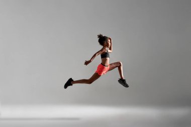 Koşu sırasında atletik siyah kızın yan görünüşü