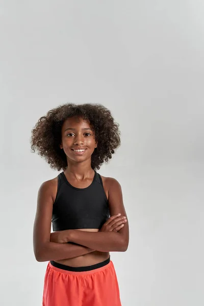 Fekete lány keresztbe tett karokkal nézi a kamerát — Stock Fotó