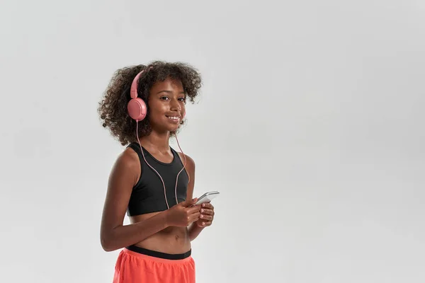 Black girl listen music in earphones on smartphone — Foto de Stock