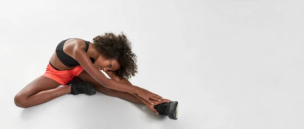 Krullend atletisch zwart meisje dragen sportkleding stretch — Stockfoto
