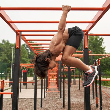 Spor çocuğu antrenman sırasında yatay çubukta döner.