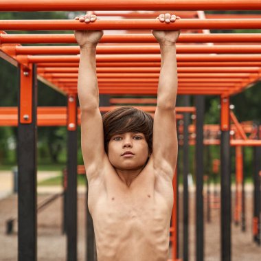 Sporcu çocuğun önünde el yürüyüşü egzersizi yapılır.