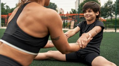 Anne ve oğul tarlada uzanırken el ele tutuşun.