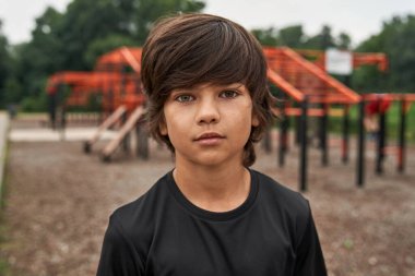 Ciddi bir sporcu çocuk kameraya bakıyor.