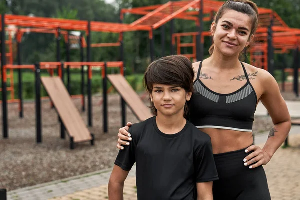 Beyaz tenli atletik anne ve oğlu kameraya bakın. — Stok fotoğraf