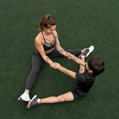 Spor sahasında gerinen atletik anne ve oğul