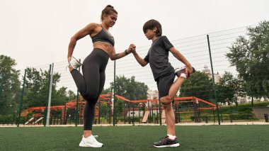 Anne ve oğulun bacak esnetme görüntüsü