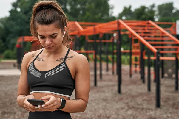 Sportvrouw die gebruikt en typt op smartphone — Stockfoto