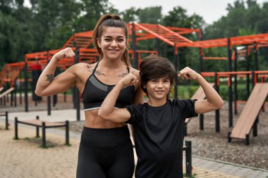 Anne ve oğul pazılarını göster ve kameraya bak.