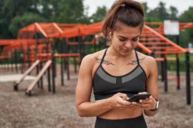 Sports woman messaging or texting on smartphone