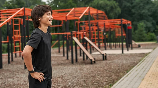 Spor sahasında gülen sporcu çocuğun yan görünüşü