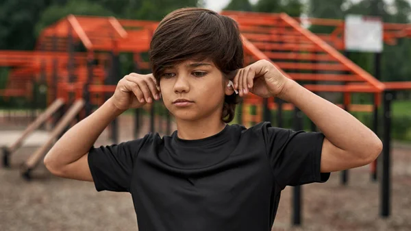 Σπορ αγόρι βάζοντας ασύρματα ακουστικά στα αυτιά — Φωτογραφία Αρχείου