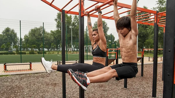 Caucasian mother and son do abs on sports ground —  Fotos de Stock