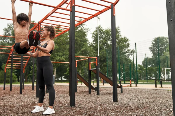 Beyaz tenli güçlü anne oğluna karın kası yapmayı öğretiyor.