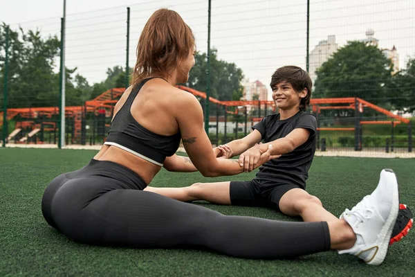 Anne ve oğlu ısınırken el ele tutuşuyorlar.