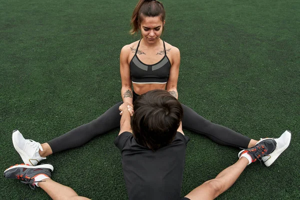 Modern anne ve oğul atletizm sahasında esniyorlar.