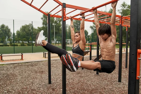 Mother and son do abs on horizontal bar together —  Fotos de Stock