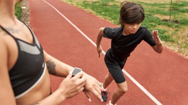 Antrenör koşan çocuğun akıllı seğirmesini not alıyor