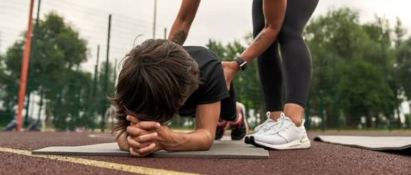 Mother teaching son doing plank on sports ground — Foto de Stock