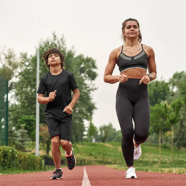 Europeisk idrottsmor och son joggar eller springer — Stockfoto