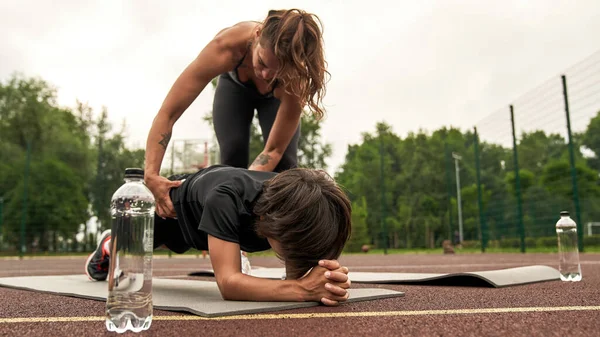Atletik anne oğluna kalas egzersizi yaptırıyor.