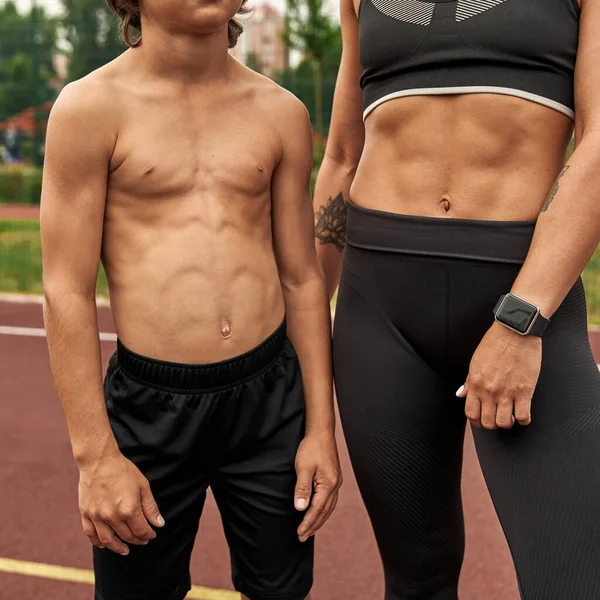 スポーツグラウンドでの陸上競技の胴を持つ女性と少年 — ストック写真