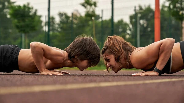 Side view of caucasian mother and son do plank — Foto de Stock