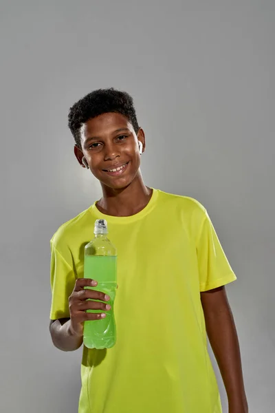 Smiling athletic boy with bottle of sport drink — Stock Photo, Image