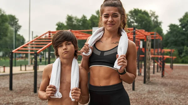 Spor sahasında havluları olan anne ve oğlu.