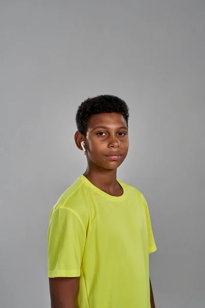 Boy wearing wireless earphones looking at camera — Stockfoto