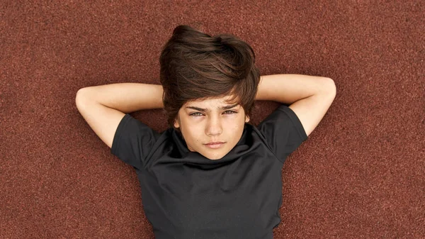 Koşu parkurunda uzanan sporcu çocuğun portresi — Stok fotoğraf