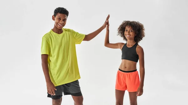 Smiling athletic girl and boy give five each other — Stok fotoğraf