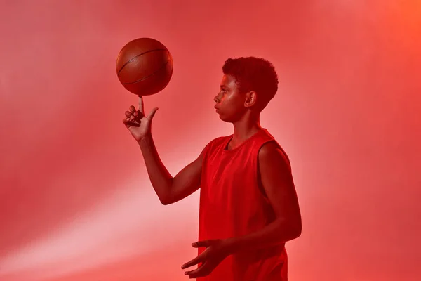 Focused boy spinning basketball ball on his finger — Stok Foto