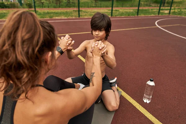 Kafkas oğlu, anneye spor minderinde çıtır çıtır yemek için yardım ediyor.