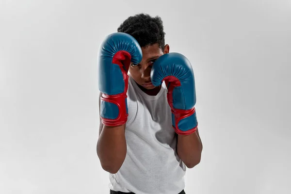 Front view of serious boy boxer boxing in studio — Stok fotoğraf