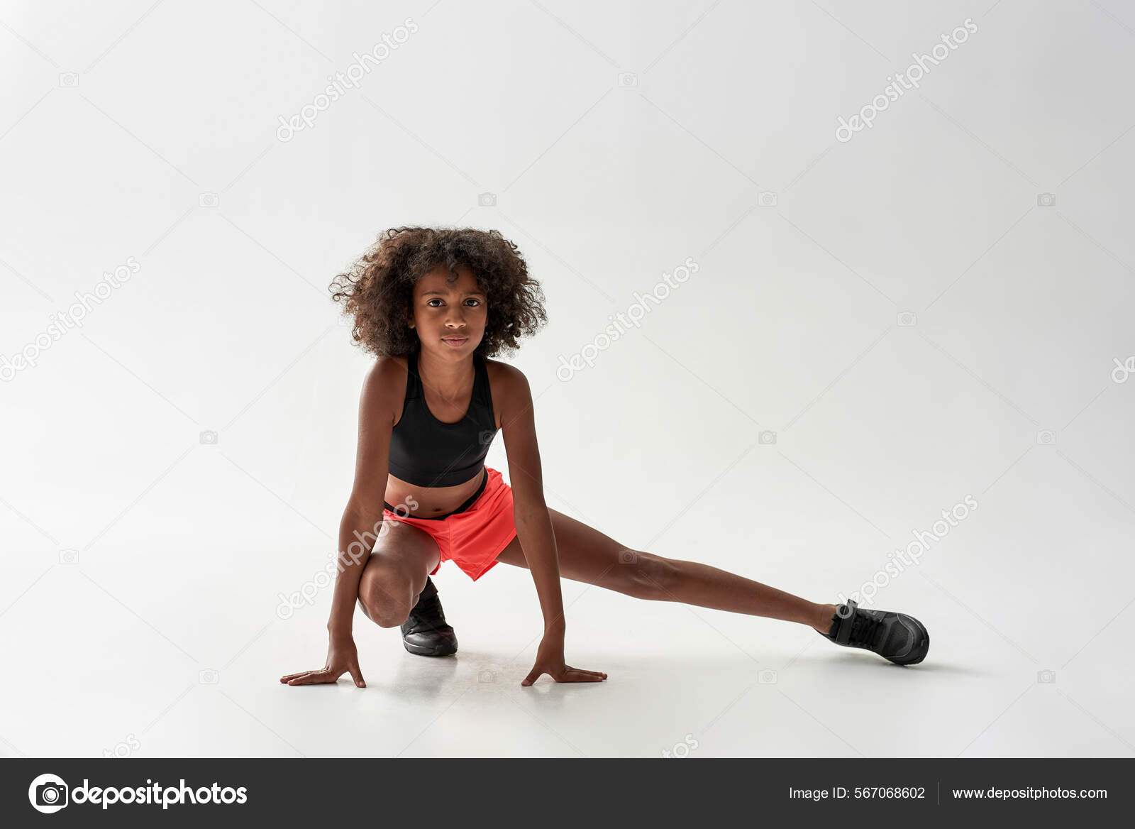 Athletic girl stretch legs and look at camera Stock Photo by