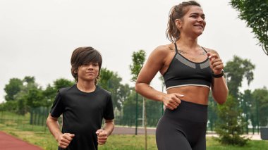 Anne ve oğlu koşuyor ya da koşuyor.