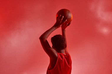 Basketbolcu çocuk topu atıyor.