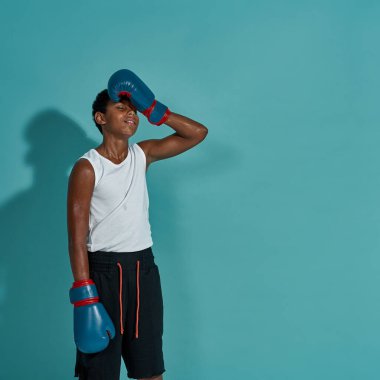 Kapalı gözlü yorgun çocuk boksör alnına dokunur