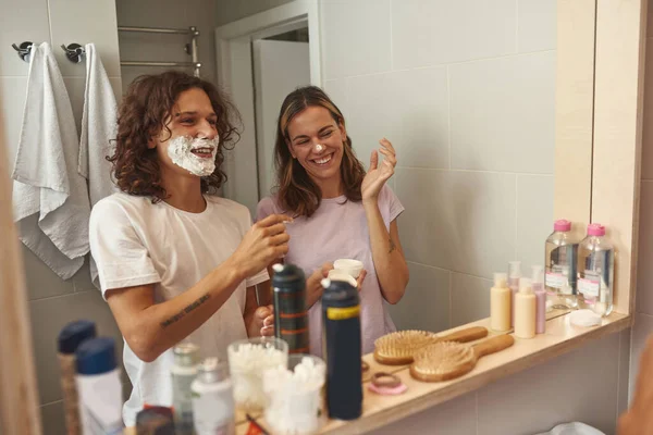 Guy smearing foam on girlfriend nose while shaving — Foto de Stock