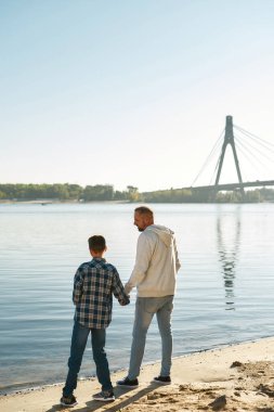 Nehir kıyısında beyin felci geçiren baba ve oğul.