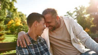 Dad and son with cerebral palsy sit head to head