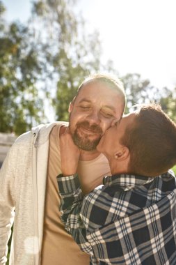 Serebral felçli çocuk gülümseyen yetişkin baba öpücüğü.