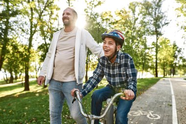 Baba oğluna beyin felci bisikletinde yardım et.