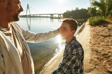 Avrupalı baba ve oğlu nehir kıyısında dinleniyor
