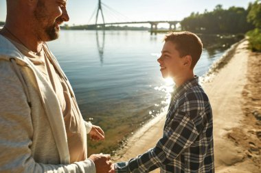Baba, nehir kıyısındaki özürlü oğluna bak.