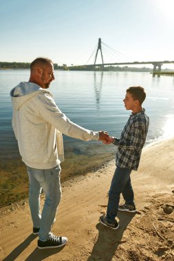 Engelli baba ve oğlu nehir kıyısında dinleniyor.